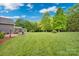 The expansive backyard features mature trees, a lush lawn, and an outdoor kitchen area perfect for entertaining at 2853 Mathis Church Rd, Catawba, NC 28609