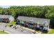 Aerial view showcasing well-maintained townhomes, parking spaces, and a serene, green backdrop at 3021 Misty Harbor Cir, Cramerton, NC 28032