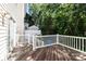 Back deck with weathered wood, white railing and access to backyard with full, mature trees at 3021 Misty Harbor Cir, Cramerton, NC 28032