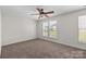 Bright bedroom with neutral carpeting, ceiling fan, and double windows allowing natural light at 3021 Misty Harbor Cir, Cramerton, NC 28032