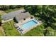 Aerial view of a fenced pool surrounded by lounge chairs, tables and lush landscaping at 3021 Misty Harbor Cir, Cramerton, NC 28032