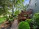 Landscaped backyard featuring a deck, stone pathway, and lush greenery creating a serene outdoor space at 3133 English Sparrow Ln, Charlotte, NC 28210