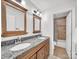 Well-lit bathroom boasts a double vanity with granite countertops, mirrors and updated lighting fixtures at 3133 English Sparrow Ln, Charlotte, NC 28210