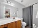 Bathroom with wood vanity, modern fixtures, a well-lit mirror, and a shower with neutral gray curtain at 3133 English Sparrow Ln, Charlotte, NC 28210