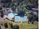 Aerial shot featuring the community pool, tennis courts, and clubhouse in a lush, wooded setting at 3133 English Sparrow Ln, Charlotte, NC 28210
