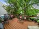 Outdoor wooden deck featuring seating, colorful pillows, and a view of the lush backyard at 3133 English Sparrow Ln, Charlotte, NC 28210