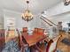 Dining area with a chandelier, hardwood floors, and staircase in the background at 3133 English Sparrow Ln, Charlotte, NC 28210