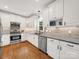 Well-lit kitchen with white cabinetry, stainless steel appliances, and hardwood floors at 3133 English Sparrow Ln, Charlotte, NC 28210