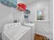 Bright laundry room with washer, dryer, and ample shelving for storage at 3133 English Sparrow Ln, Charlotte, NC 28210