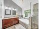 Bright bathroom featuring a soaking tub, walk-in shower, double vanity and natural light from a large window at 3133 English Sparrow Ln, Charlotte, NC 28210