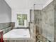 The bathroom has a jetted tub beneath the window, and a tiled shower with glass door enclosure at 3133 English Sparrow Ln, Charlotte, NC 28210
