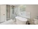 Luxurious bathroom featuring a soaking tub, walk-in shower, and marble accents at 3223 Rheinwood Ct, Matthews, NC 28105
