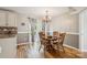 Bright dining area featuring a wood table, decorative chandelier, and sliding door to the outdoor balcony at 3223 Rheinwood Ct, Matthews, NC 28105