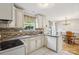 Bright kitchen featuring white cabinets, tiled backsplash, and modern appliances at 3223 Rheinwood Ct, Matthews, NC 28105