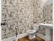 Stylish powder room featuring elegant fern wallpaper, pedestal sink, and hardwood flooring at 397 Luray Way, Rock Hill, SC 29730
