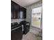 Well-organized laundry room with black cabinets, modern machines, and stylish wallpaper at 397 Luray Way, Rock Hill, SC 29730