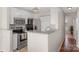 Bright kitchen with granite countertops and stainless steel appliances, leading to hallway at 4072 Town Center Rd, Harrisburg, NC 28075