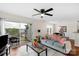 Cozy living room with wood floors, ceiling fan, balcony access, and dining area at 4072 Town Center Rd, Harrisburg, NC 28075