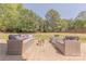 Spacious brick backyard patio featuring wicker seating around a modern fire pit, perfect for outdoor gatherings at 4117 Wallbrook Dr, Matthews, NC 28105