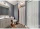This full bathroom features tile flooring, a shower with curtain, and a single sink vanity at 4117 Wallbrook Dr, Matthews, NC 28105