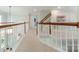 Carpeted upstairs hallway with wood railing and stairway at 4117 Wallbrook Dr, Matthews, NC 28105