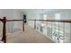 Upstairs hallway featuring carpeting and wood railing overlooking the living room at 4117 Wallbrook Dr, Matthews, NC 28105