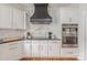 Gourmet kitchen featuring stainless steel appliances, white cabinets, and a black range hood at 4117 Wallbrook Dr, Matthews, NC 28105
