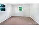Empty bedroom featuring carpeted floors, neutral tones, and natural light from the window at 412 Brook St, Salisbury, NC 28146