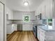 Well-lit kitchen featuring white cabinets, stainless steel appliances, and hardwood floors at 412 Brook St, Salisbury, NC 28146