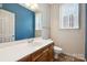 Updated bathroom features a blue accent wall, white countertops, wood cabinets, and a toilet at 4161 Deerfield Dr, Concord, NC 28027