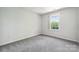 Bright, neutral bedroom featuring a large window and plush carpet at 4161 Deerfield Dr, Concord, NC 28027