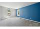 Spacious bedroom with a blue accent wall, plush carpet and natural light from two windows at 4161 Deerfield Dr, Concord, NC 28027