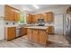 Sunlit kitchen features an island, stainless steel appliances, light wood cabinets and a window above the sink at 4161 Deerfield Dr, Concord, NC 28027