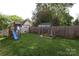 Spacious backyard with a well-maintained lawn, playset, and fenced garden area at 421 Mcdonald Ave, Charlotte, NC 28203