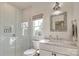 Clean bathroom with a glass enclosed shower, white vanity, and decorative mirror at 421 Mcdonald Ave, Charlotte, NC 28203