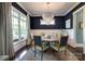 Elegant dining room featuring dark blue walls, a statement chandelier, and ample natural light at 421 Mcdonald Ave, Charlotte, NC 28203