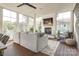 Inviting sunroom with wood floors, white brick fireplace, comfortable couch, and plenty of natural light at 421 Mcdonald Ave, Charlotte, NC 28203