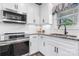 Contemporary kitchen featuring white cabinets, granite countertops, and modern appliances, creating a sleek and efficient cooking space at 4949 Southview Dr, Hickory, NC 28602