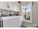 Laundry room with washer, dryer, white cabinets, and natural light from a window at 4949 Southview Dr, Hickory, NC 28602