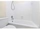 Clean, white tiled bathroom with a tub and toilet at 5601 Carmel Station Ave, Charlotte, NC 28226