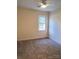 Bedroom with neutral carpet, light walls, and a bright window at 5601 Carmel Station Ave, Charlotte, NC 28226