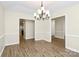 Elegant dining area with hardwood floors, a chandelier, and open access to other rooms at 5601 Carmel Station Ave, Charlotte, NC 28226