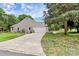 Ranch style home featuring an attached garage, long driveway, and green lawn at 5601 Carmel Station Ave, Charlotte, NC 28226