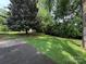 Expansive backyard with lush green grass and mature trees, offering plenty of space for outdoor activities at 5938 Sharon Rd, Charlotte, NC 28210