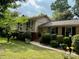 Inviting home with a charming front yard, manicured greenery, and a covered porch perfect for relaxing outdoors at 5938 Sharon Rd, Charlotte, NC 28210