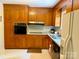 Functional kitchen features classic wooden cabinets, modern appliances, and checkered vinyl flooring at 5938 Sharon Rd, Charlotte, NC 28210