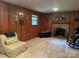 Living room with a brick fireplace, wood paneling, and plenty of natural light at 5938 Sharon Rd, Charlotte, NC 28210