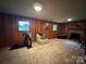 This living room has wood paneled walls, two windows, and a brick fireplace at 5938 Sharon Rd, Charlotte, NC 28210