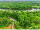 A scenic aerial view showcases lush green forests, a tranquil river, and a charming pavilion at 724 Lagan Ct, Fort Mill, SC 29715