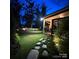 Well-manicured backyard with illuminated pathway, lush greenery, and inviting outdoor space at twilight at 724 Lagan Ct, Fort Mill, SC 29715